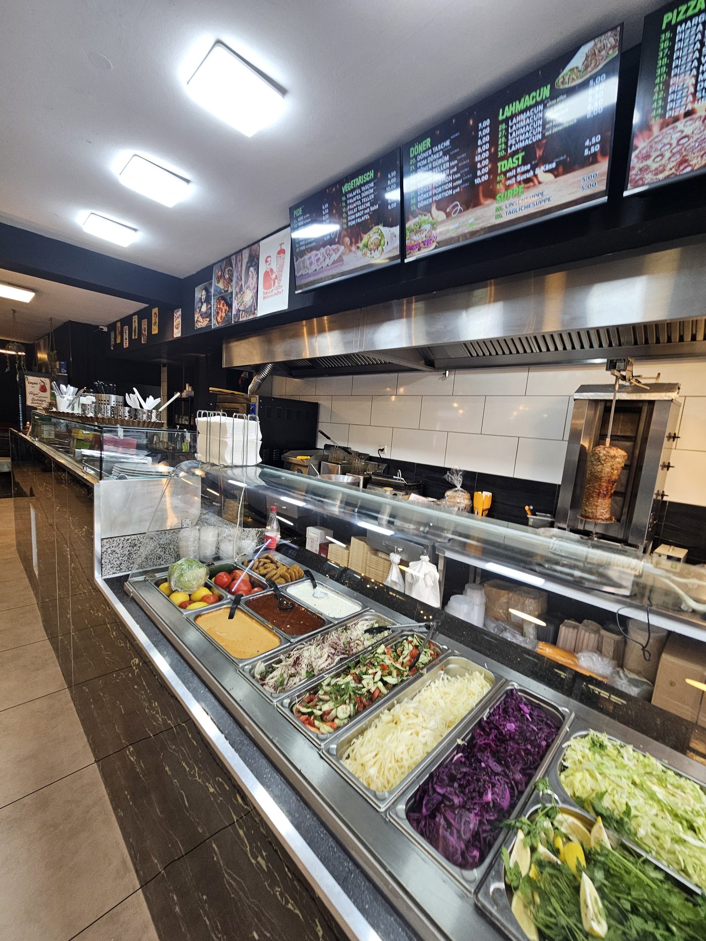 Frische Salate und Zutaten an der Theke, D&ouml;nerspie&szlig; im Hintergrund