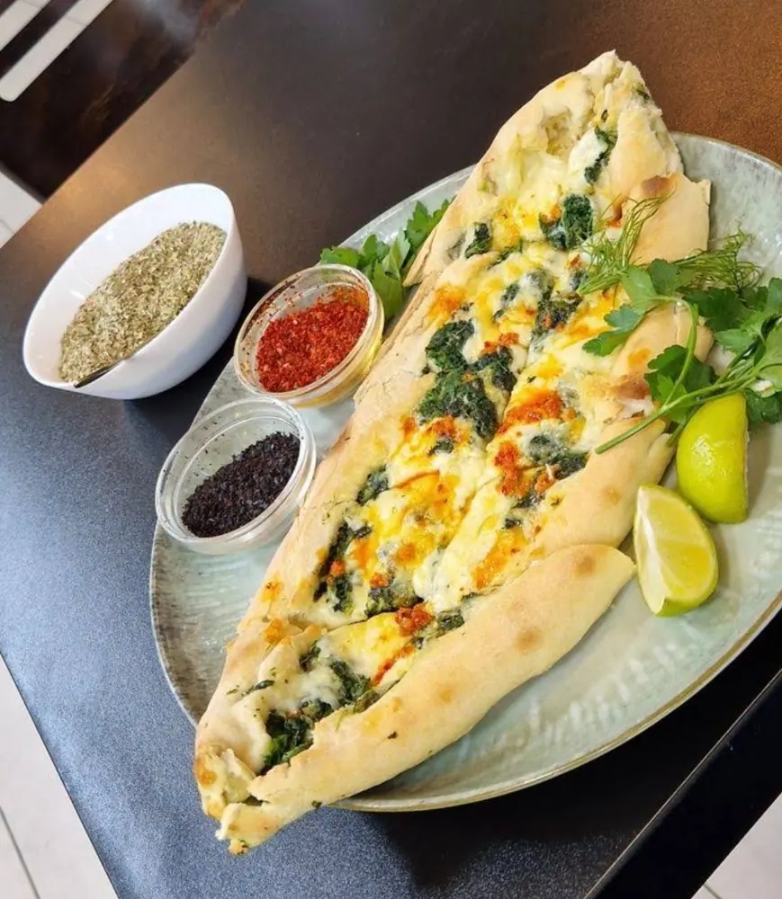 Baharat ve misket limonuyla fırından yeni çıkmış ıspanaklı peynirli pide